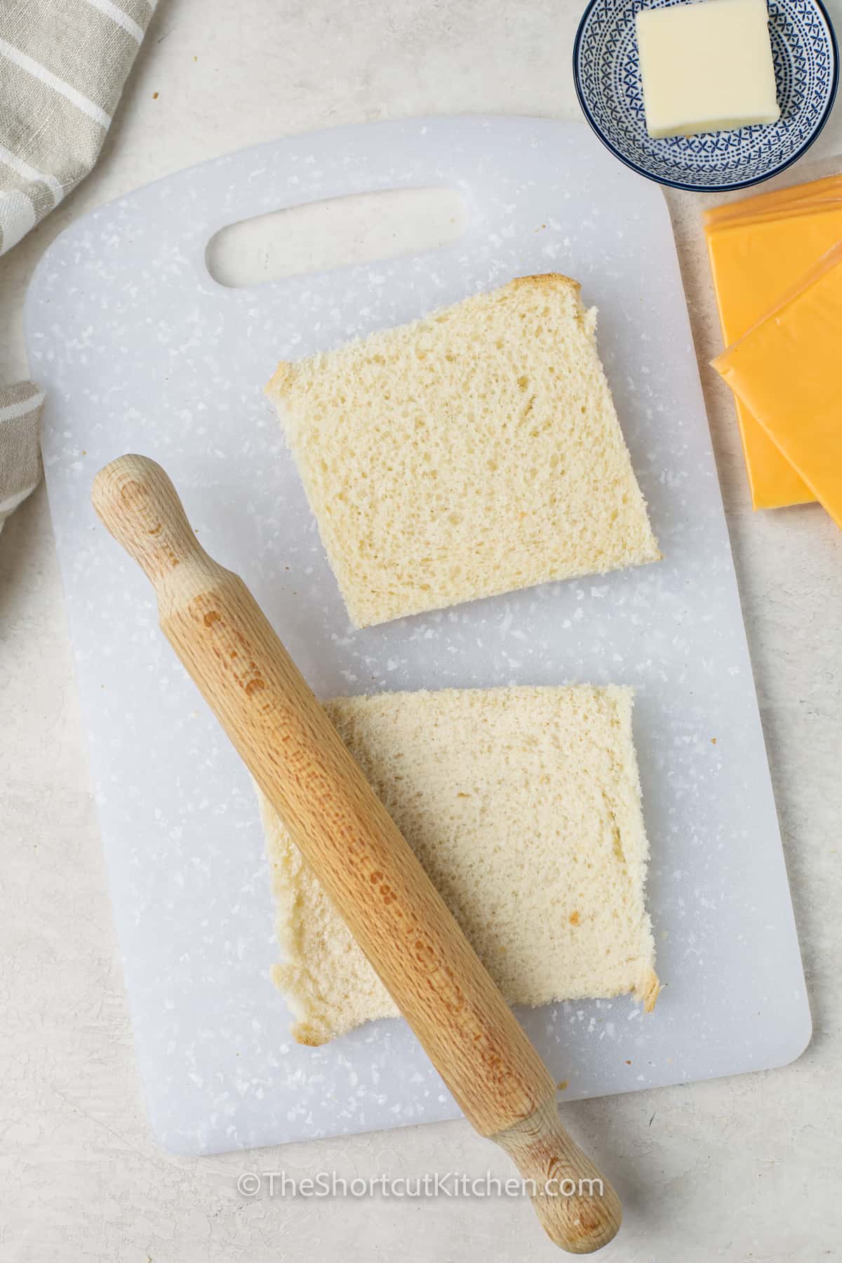 rolling bread to make Grilled Cheese Roll Ups