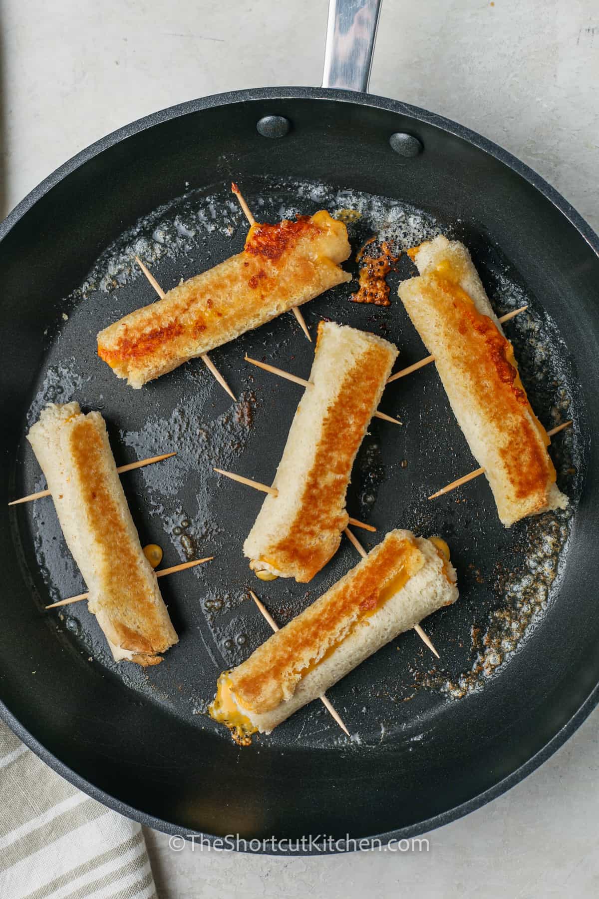 cooked Grilled Cheese Roll Ups in the pan