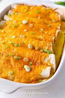 close up of baked breakfast enchiladas recipe in a white baking dish