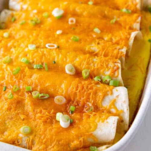 close up of baked breakfast enchiladas recipe in a white baking dish