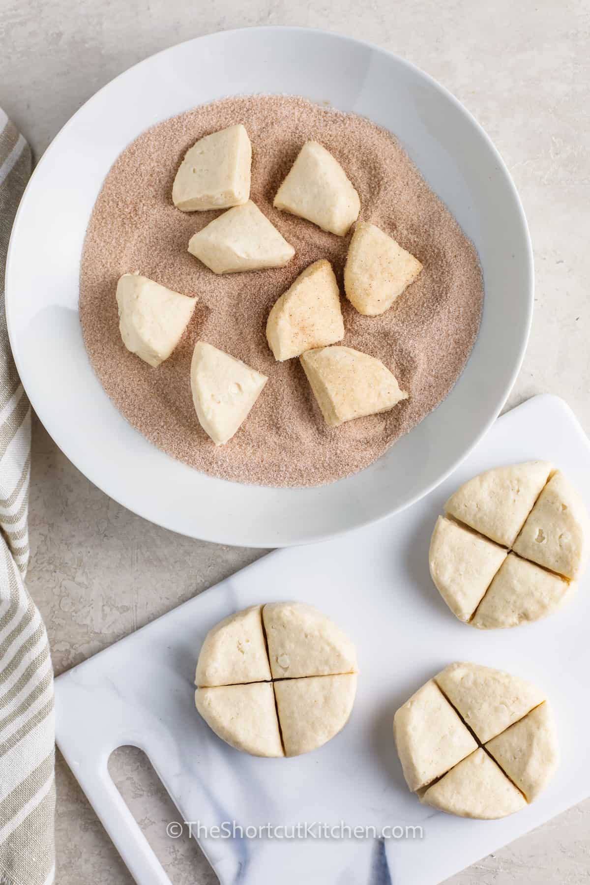 dipping bread pieces in cinnamon mixture to make easy recipe for Monkey Bread