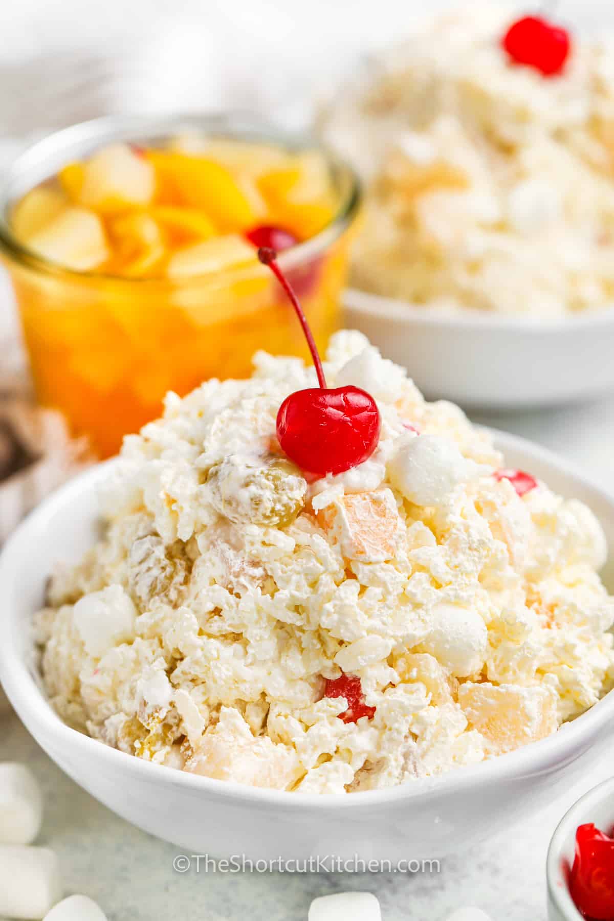 Glorified Rice in a bowl with fruit cocktail in the back