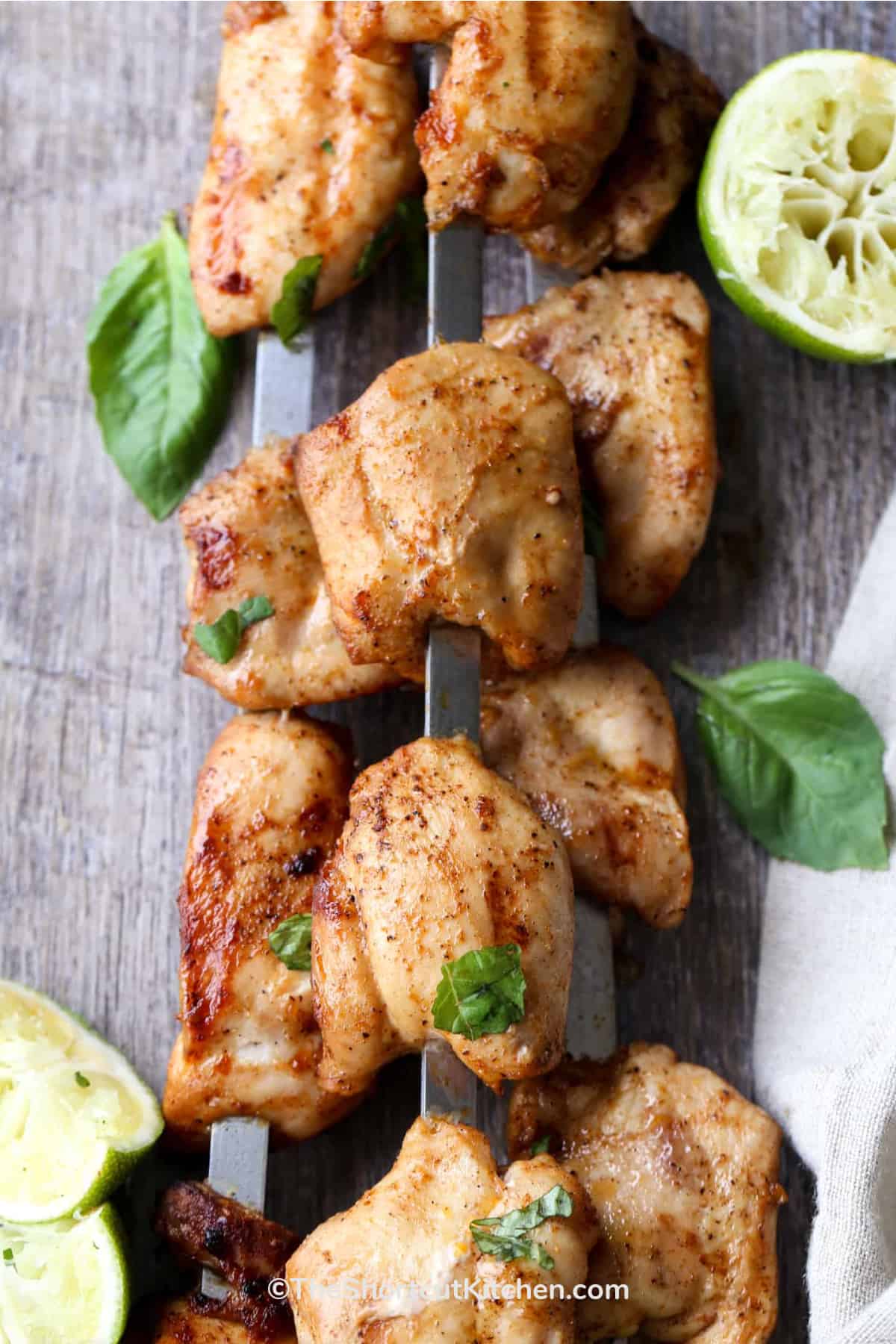 3 skewers of lime grilled chicken kabobs stacked on one another.