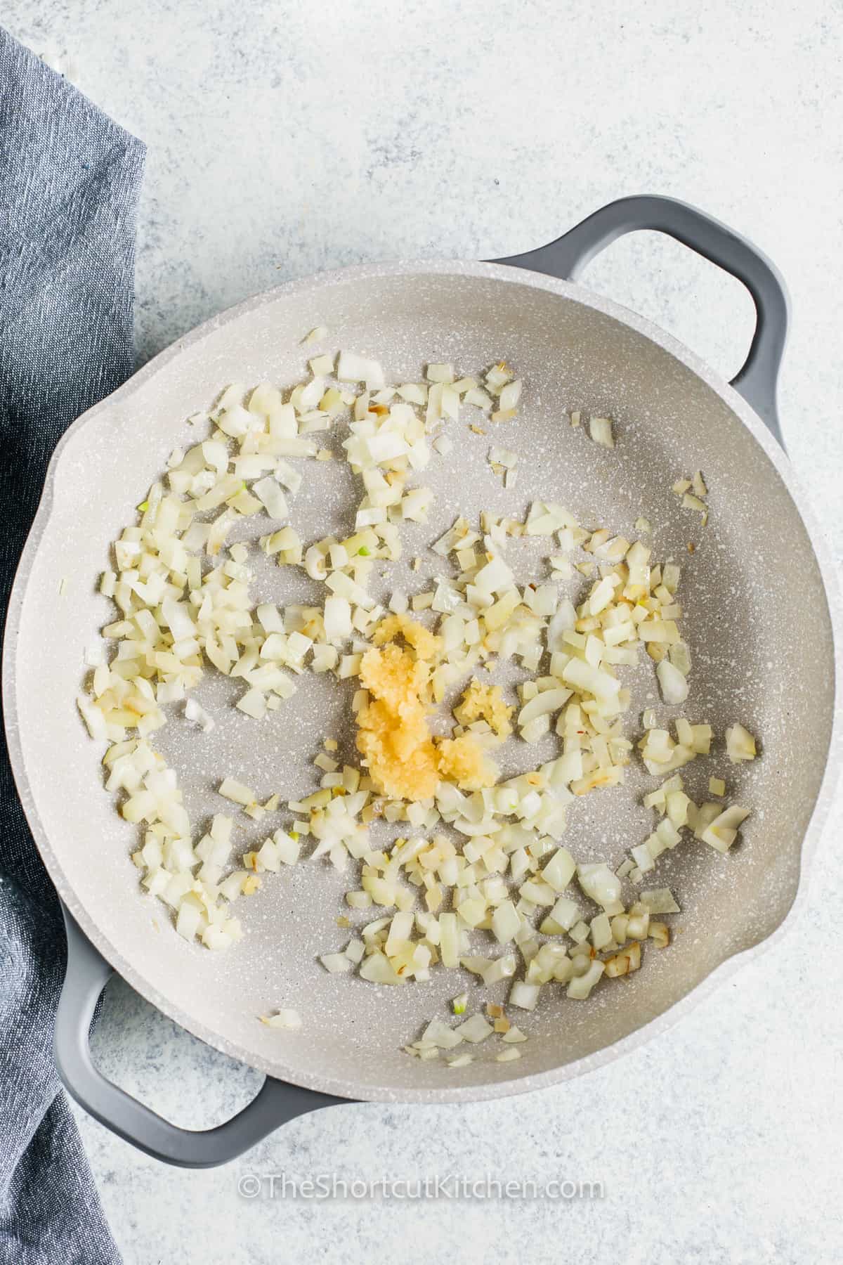 onion and garlic in a pan to make Shortcut Creamy Tomato Pasta with Chicken