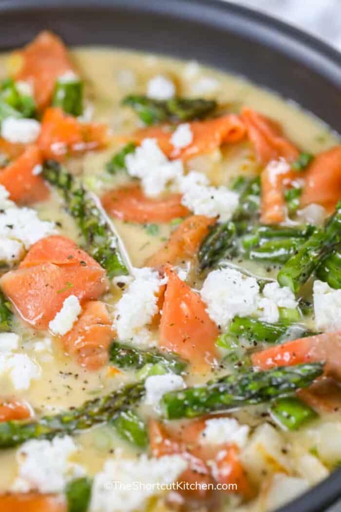 close up of salmon asparagus frittata being cooked in a pan