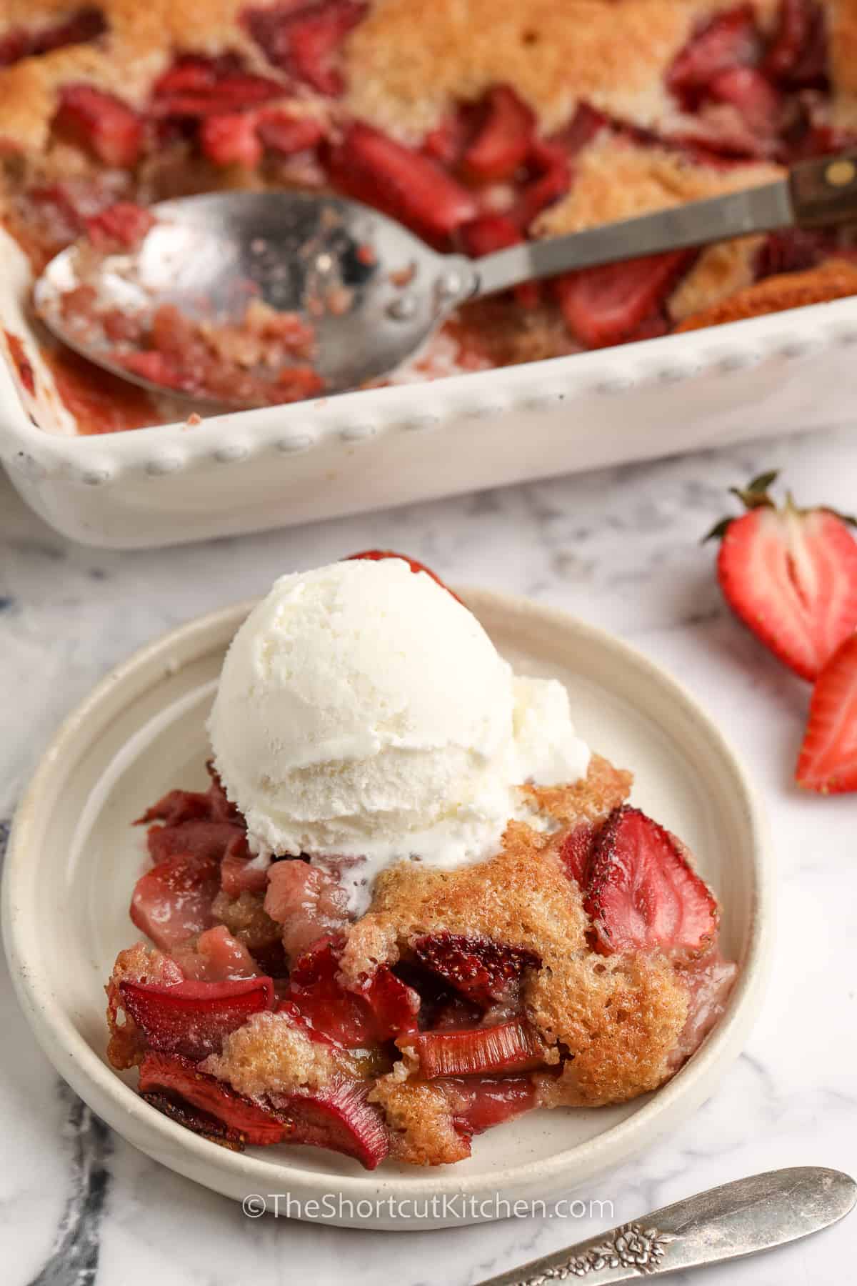 plated Strawberry Rhubarb Cobbler with dish full in the back