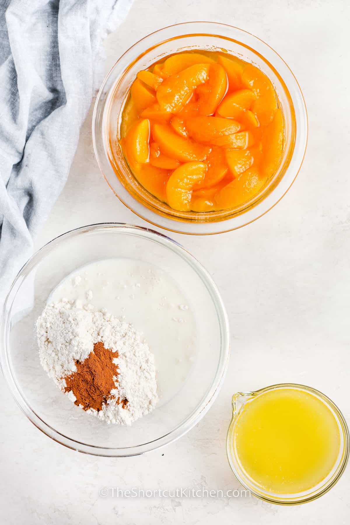 dry ingredients in a bowl with a bowl of peaches and cup of melted butter to make Bisquick Peach Cobbler Recipe