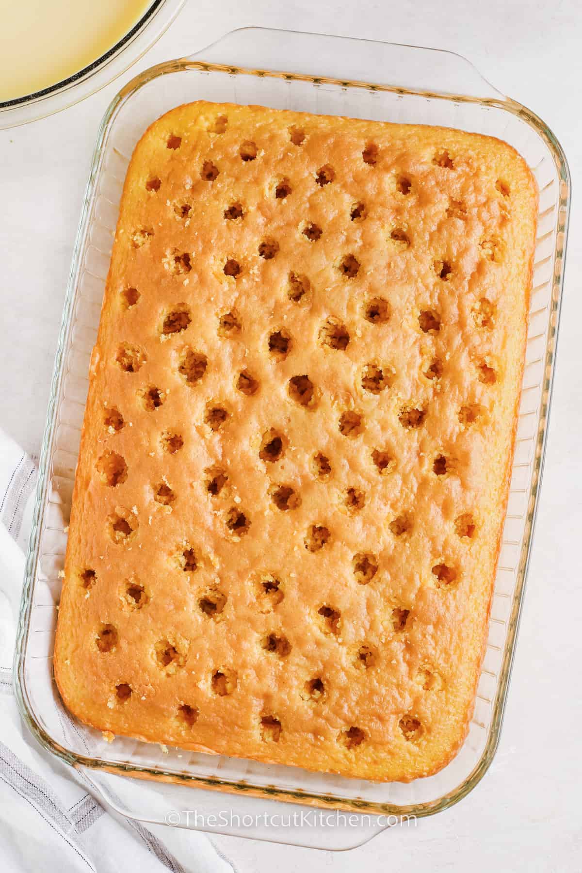 yellow cake with holes poked in it