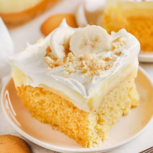 A slice of banana pudding poke cake being served on a plate.