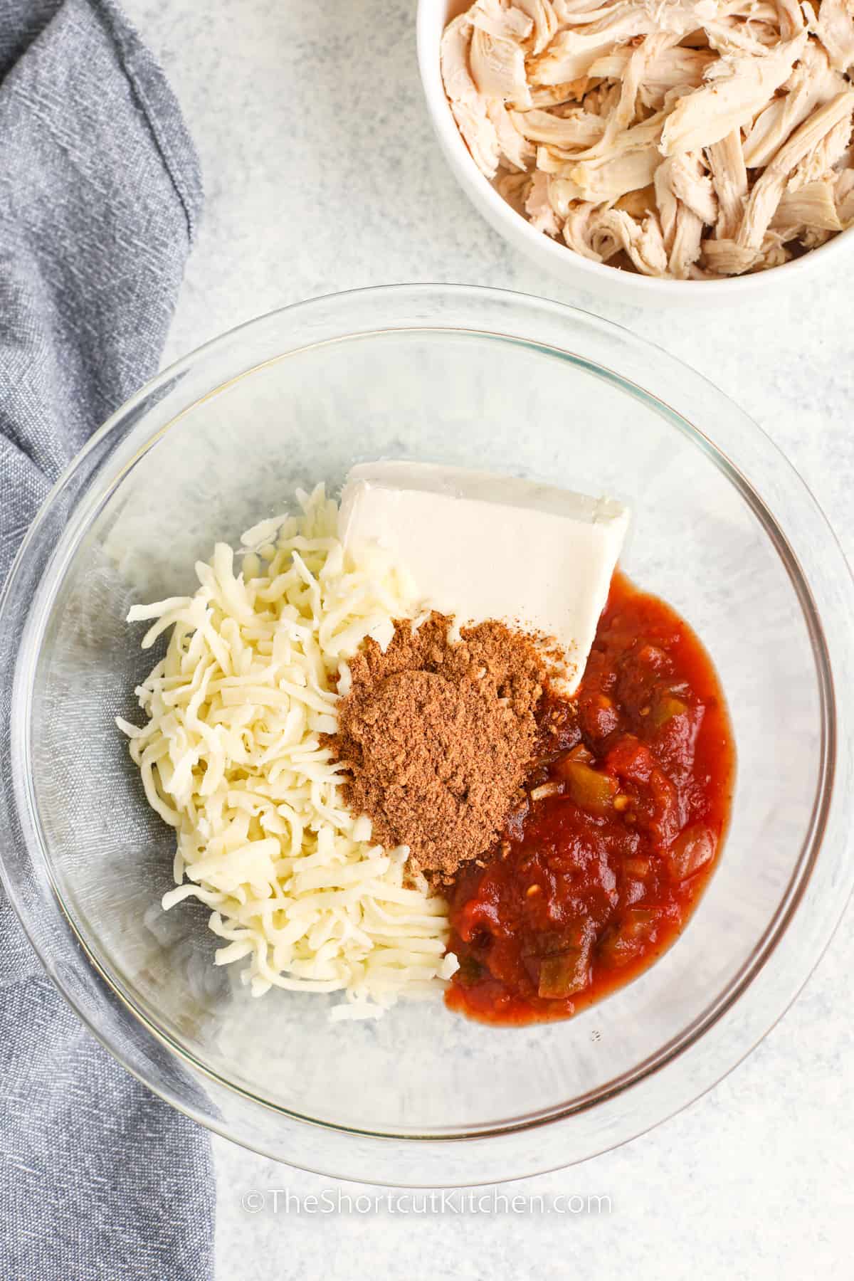 adding seasonings and salsa to cheese to make filling for Chicken Taquitos