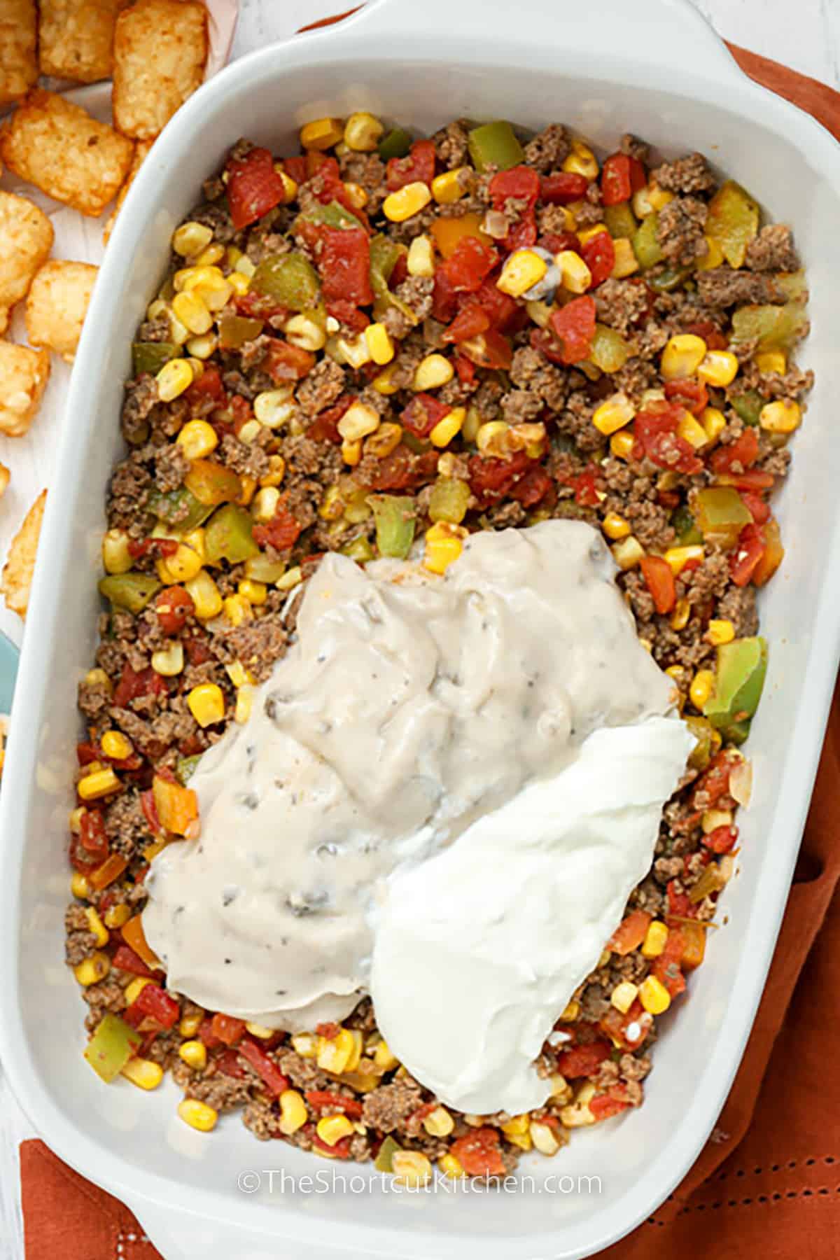 adding sauce to beef and vegetables to make Cowboy Casserole