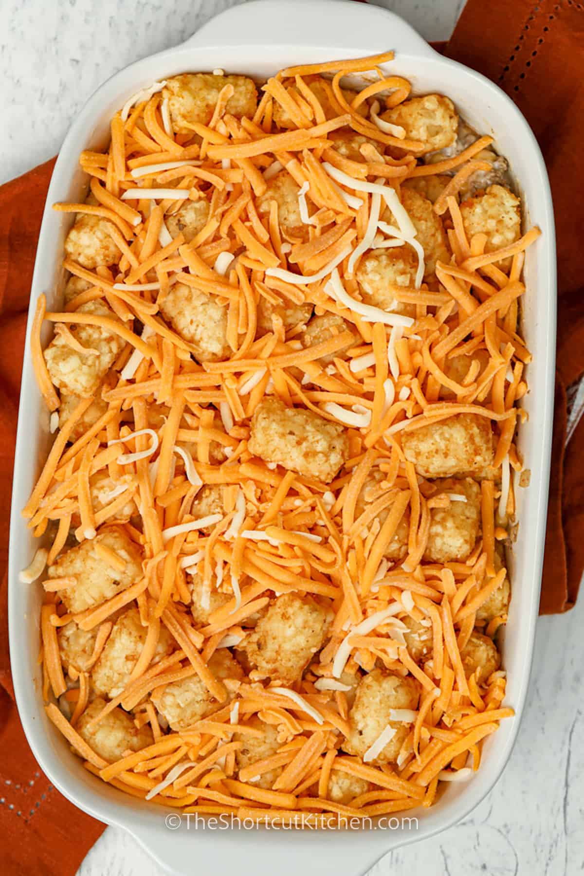 adding cheese and tater tots to Cowboy Casserole dish