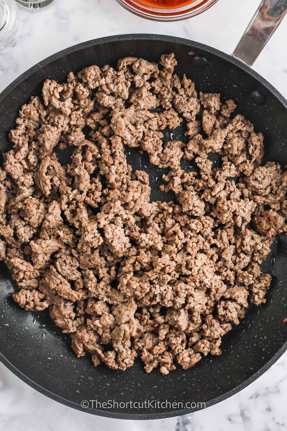 Ground beef being browned in a frying pan.