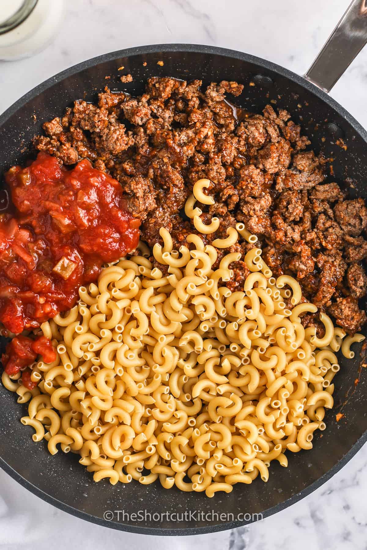 pasta, tomatoes, and ground beef in a frying pan