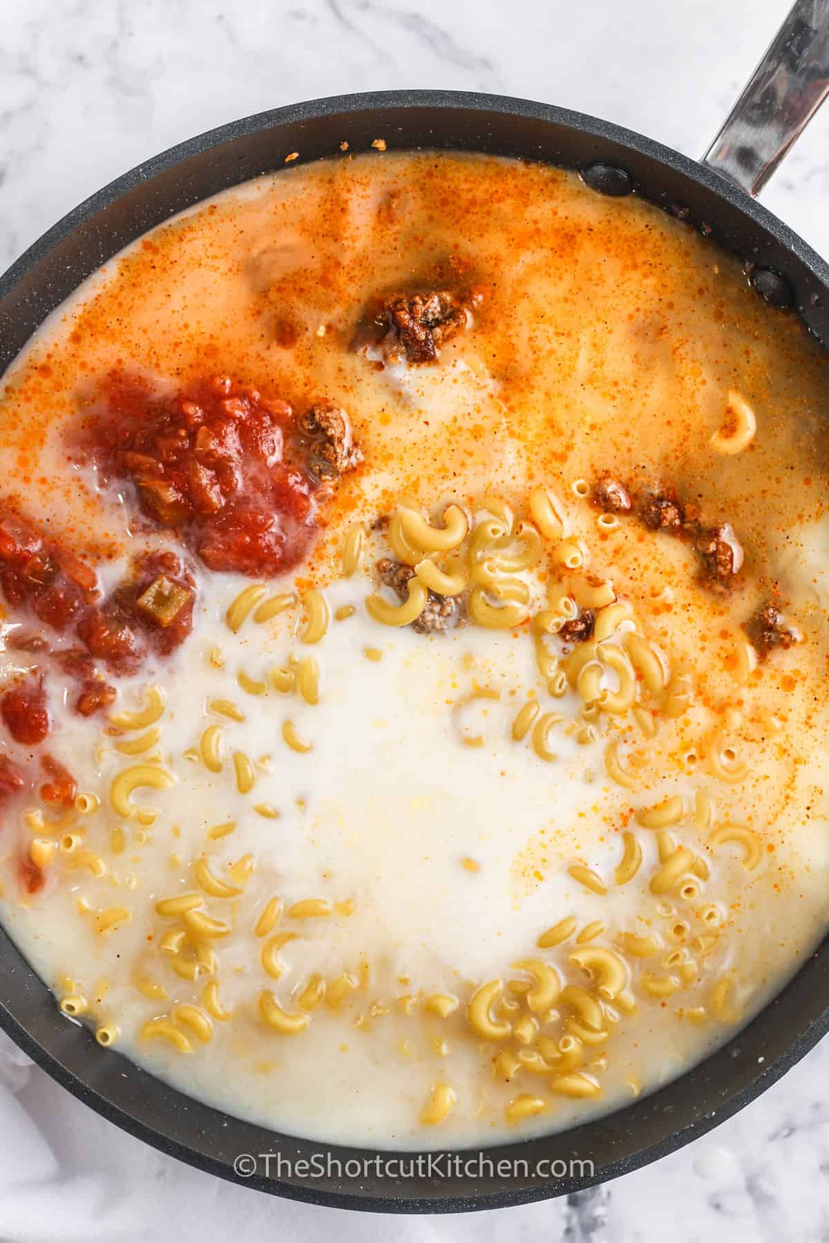 Ingredients to make taco mac and cheese in a frying pan