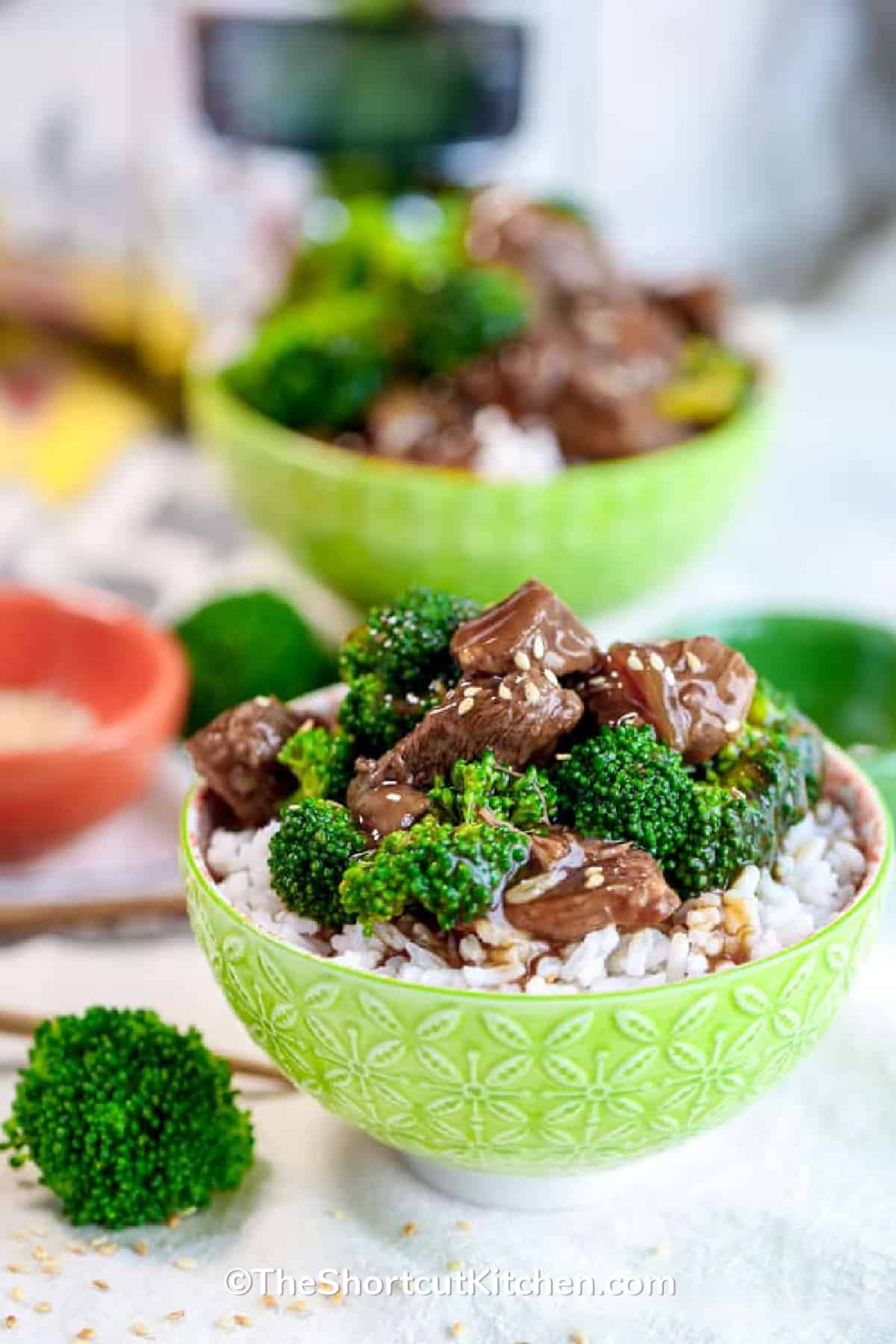 Crockpot beef and broccoli in a green bowl served over rice