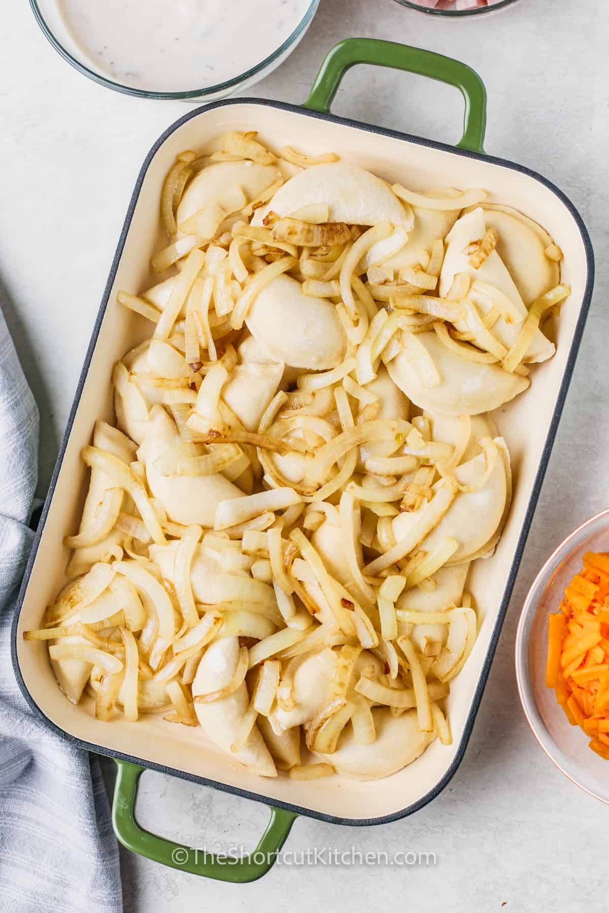 pierogies topped with sautéed onions in a casserole dish