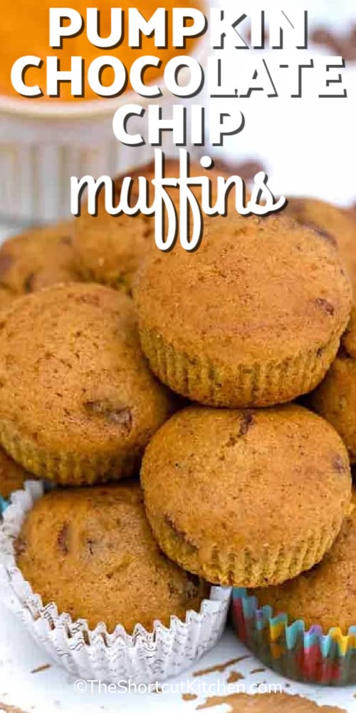 pumpkin chocolate chip muffins piled together on a wooden board, with a title