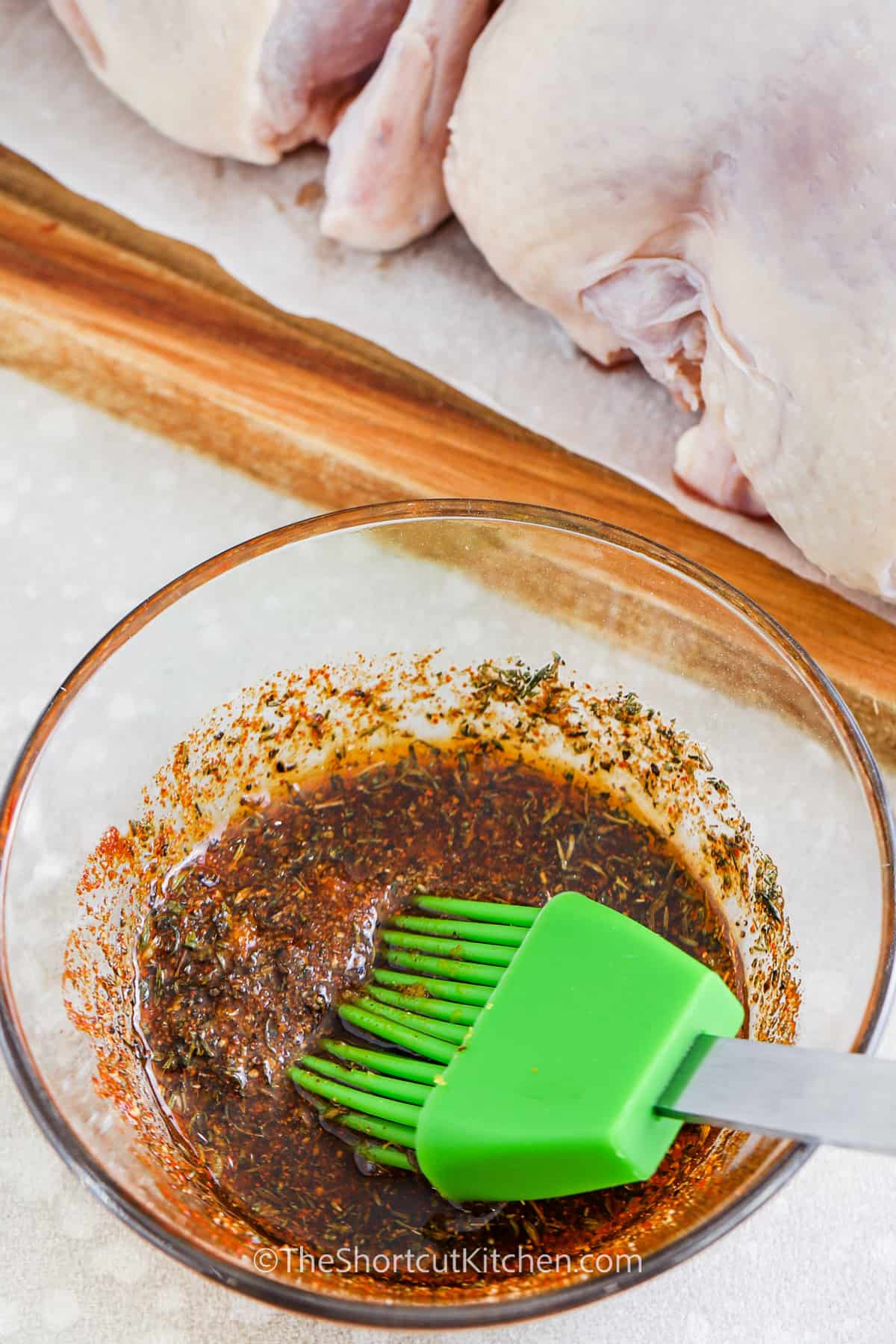 Olive oil and chicken seasoning mixed in a bowl to be brushed on the Cornish hen