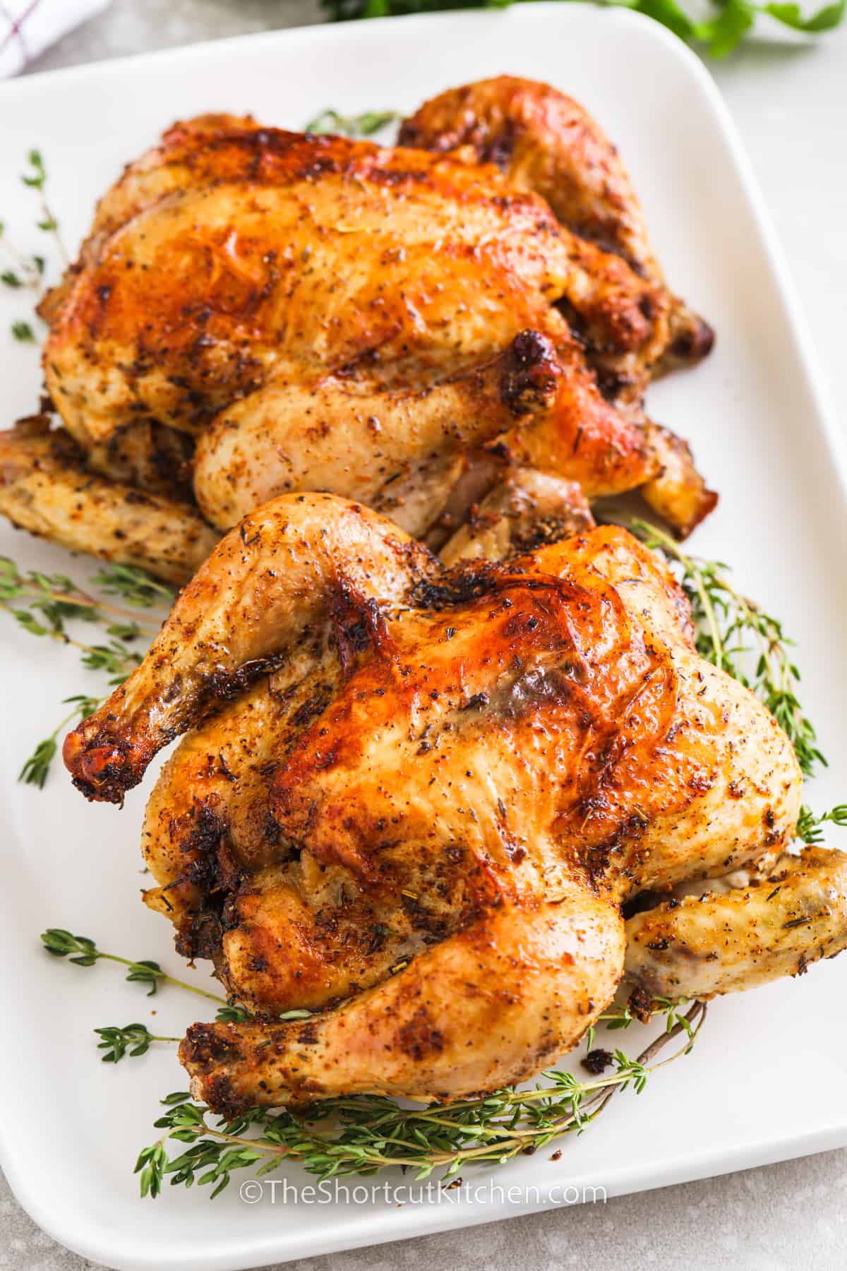 Two Oven baked Cornish Hen on a bed of thyme on a serving tray