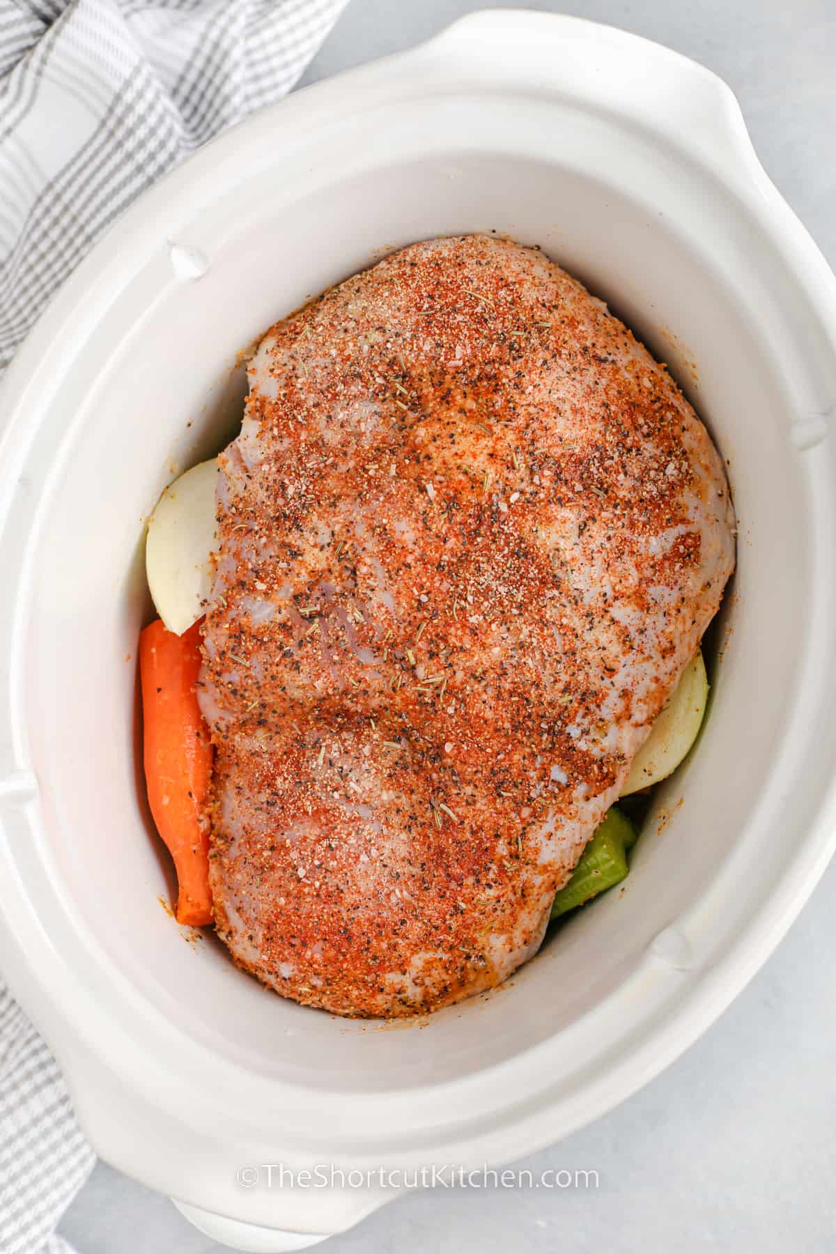 raw turkey breast in a crockpot before being cooked for crockpot turkey breast
