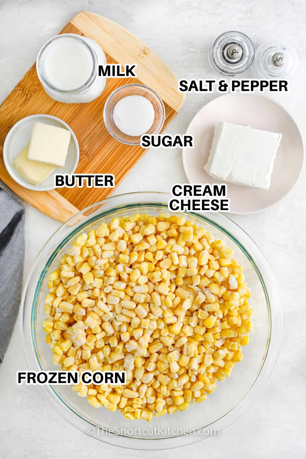 Ingredients to make crockpot creamed corn labeled: milk, sugar, butter, cream cheese, salt, pepper, and frozen corn