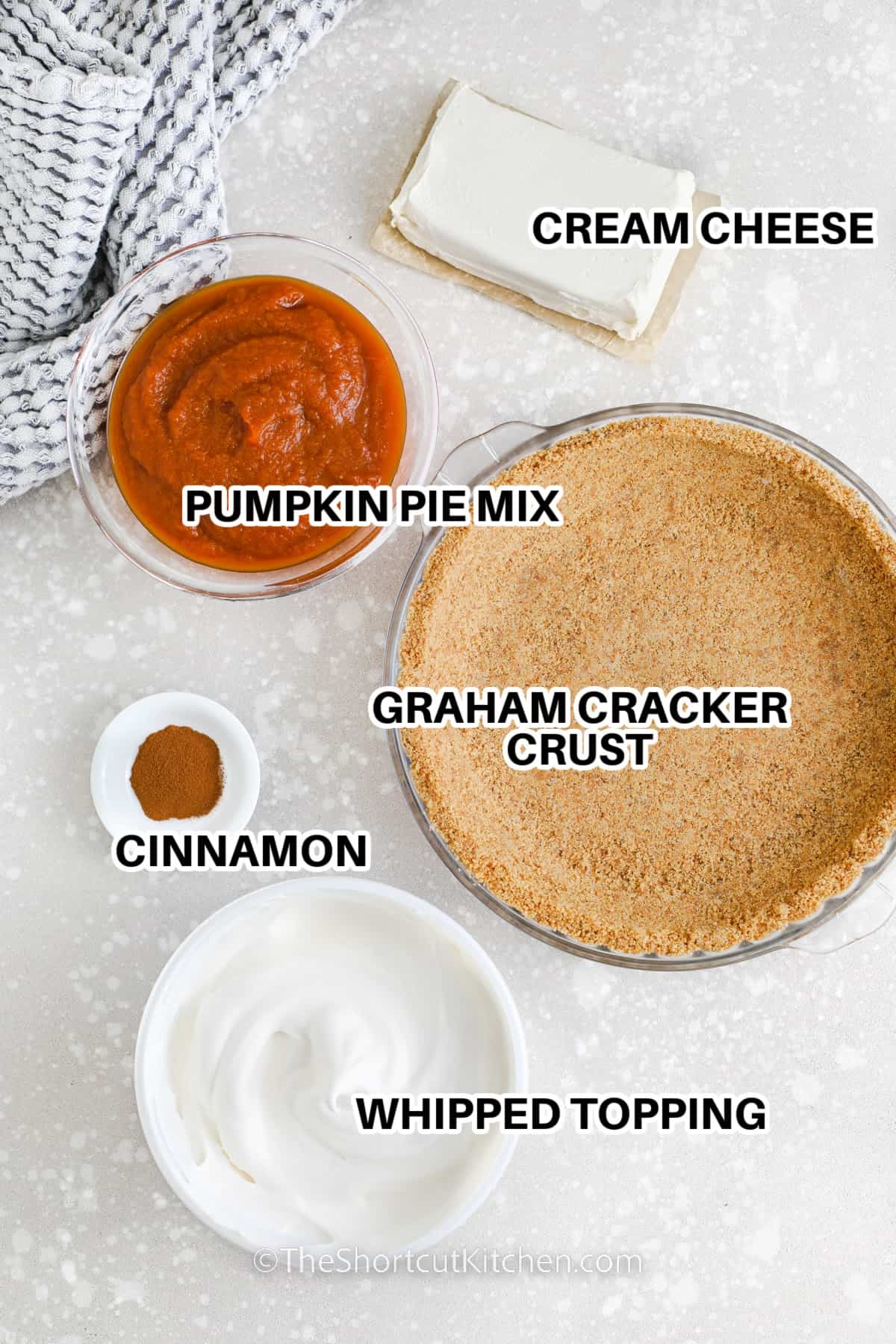 Ingredients to make a no bake pumpkin pie labeled: pumpkin pie mix, cream cheese, graham cracker crust, cinnamon, whipped topping