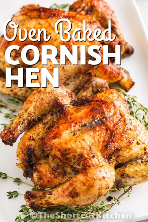 Two baked cornish hen on a bed of thyme on a serving tray with a title