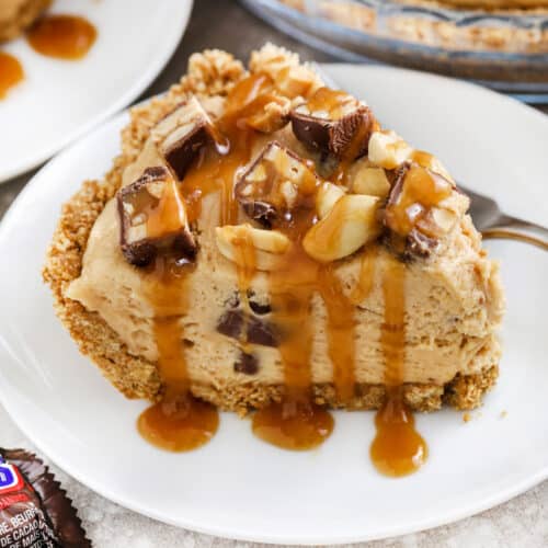a slice of snickers pie topped with caramel sauce