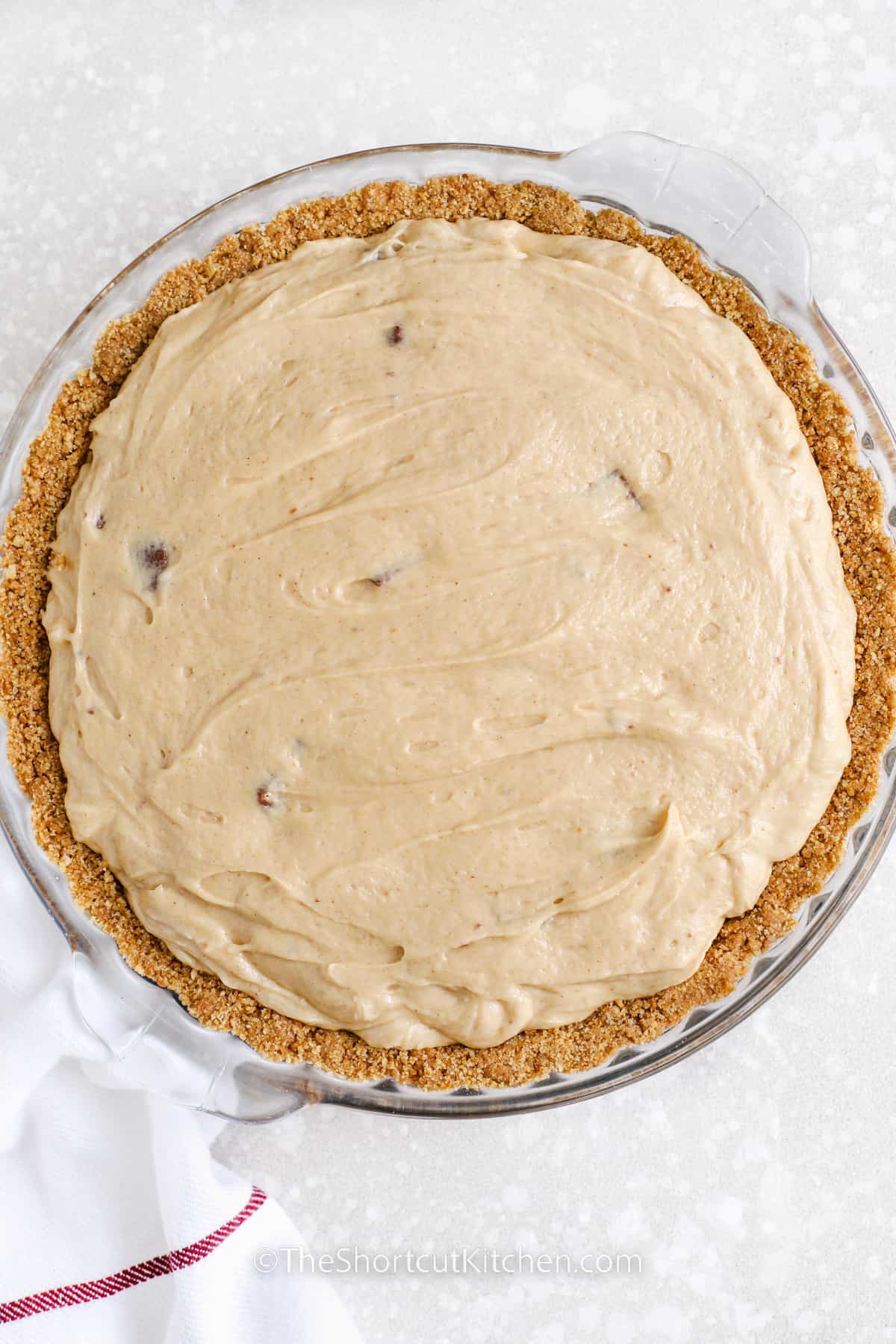 a snickers pie assembled in a graham cracker crust