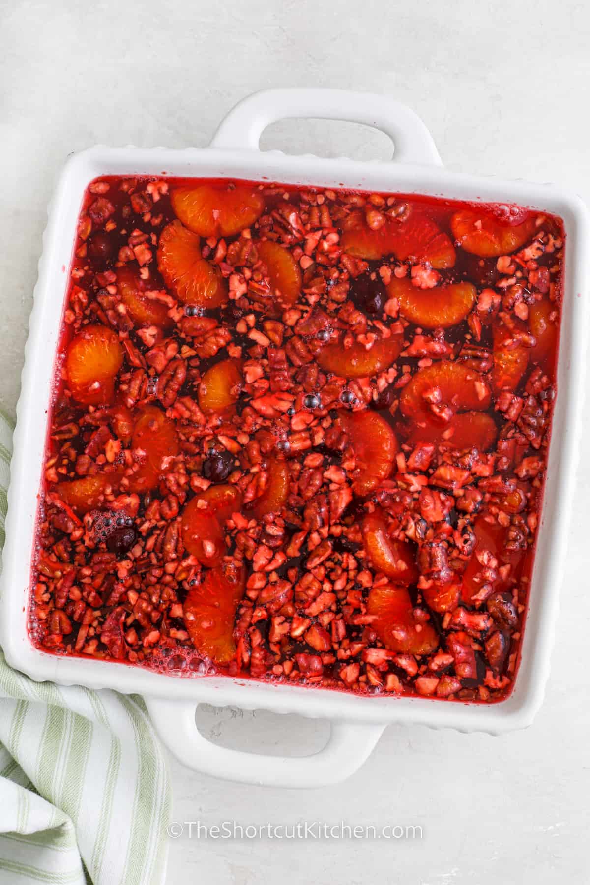 cranberry jello salad ingredients in a white casserole dish