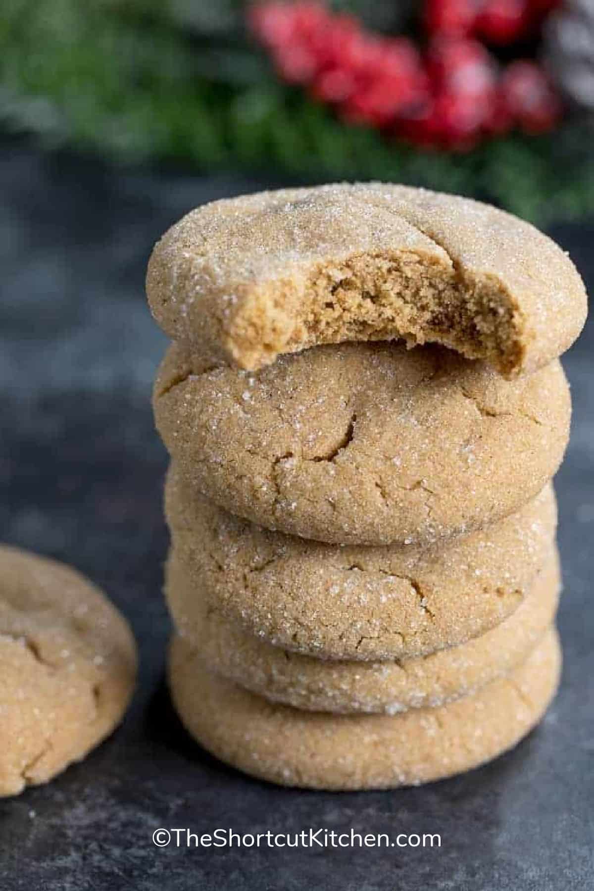stack of molasses cookies with a bite taken out of the top one