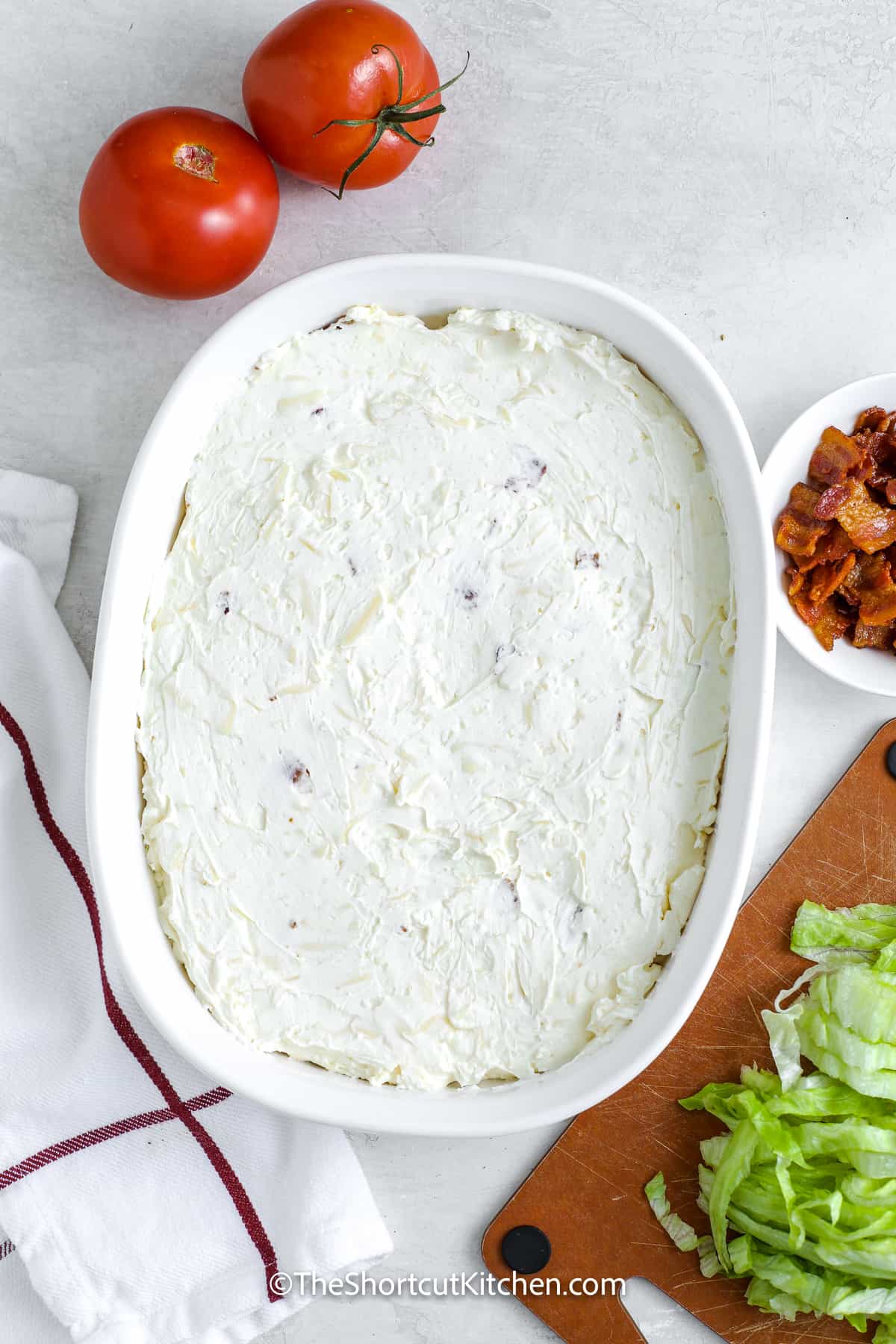 partial layers of creamy BLT dip in a dish