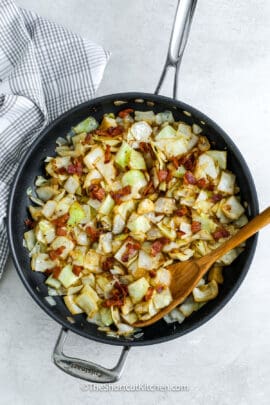 top view of fried cabbage with bacon in a frying pan