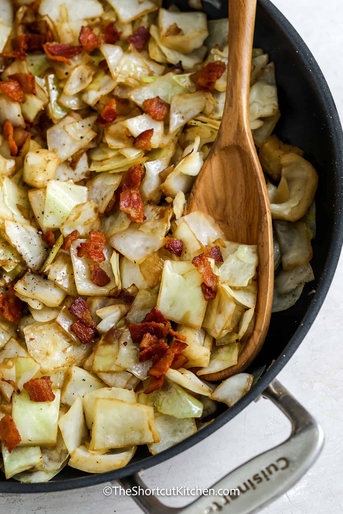 fried cabbage with bacon in a frying pan