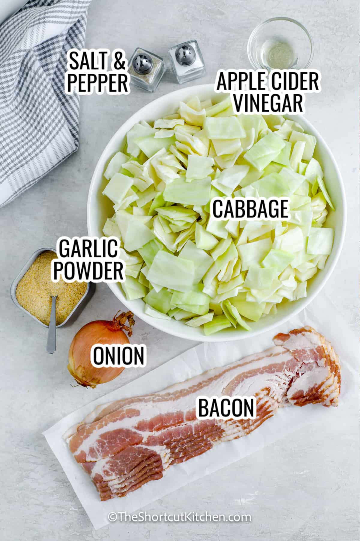 Make fried cabbage with bacon for an easy weeknight cabbage side dish with big smoky flavor. Crisp bacon, sauté onion, then cook chopped cabbage until tender and lightly golden. Finish with apple cider vinegar, salt, and pepper, then top with bacon. This sautéed cabbage recipe is fast, comforting, and made in one skillet. #theshortcutkitchen ingredients assembled to make fried cabbage with bacon, including cabbage, bacon, onion, garlic powder, and apple cider vinegar