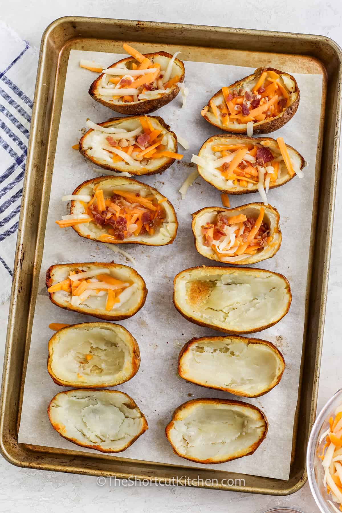 potato skins being filled with bacon and cheese