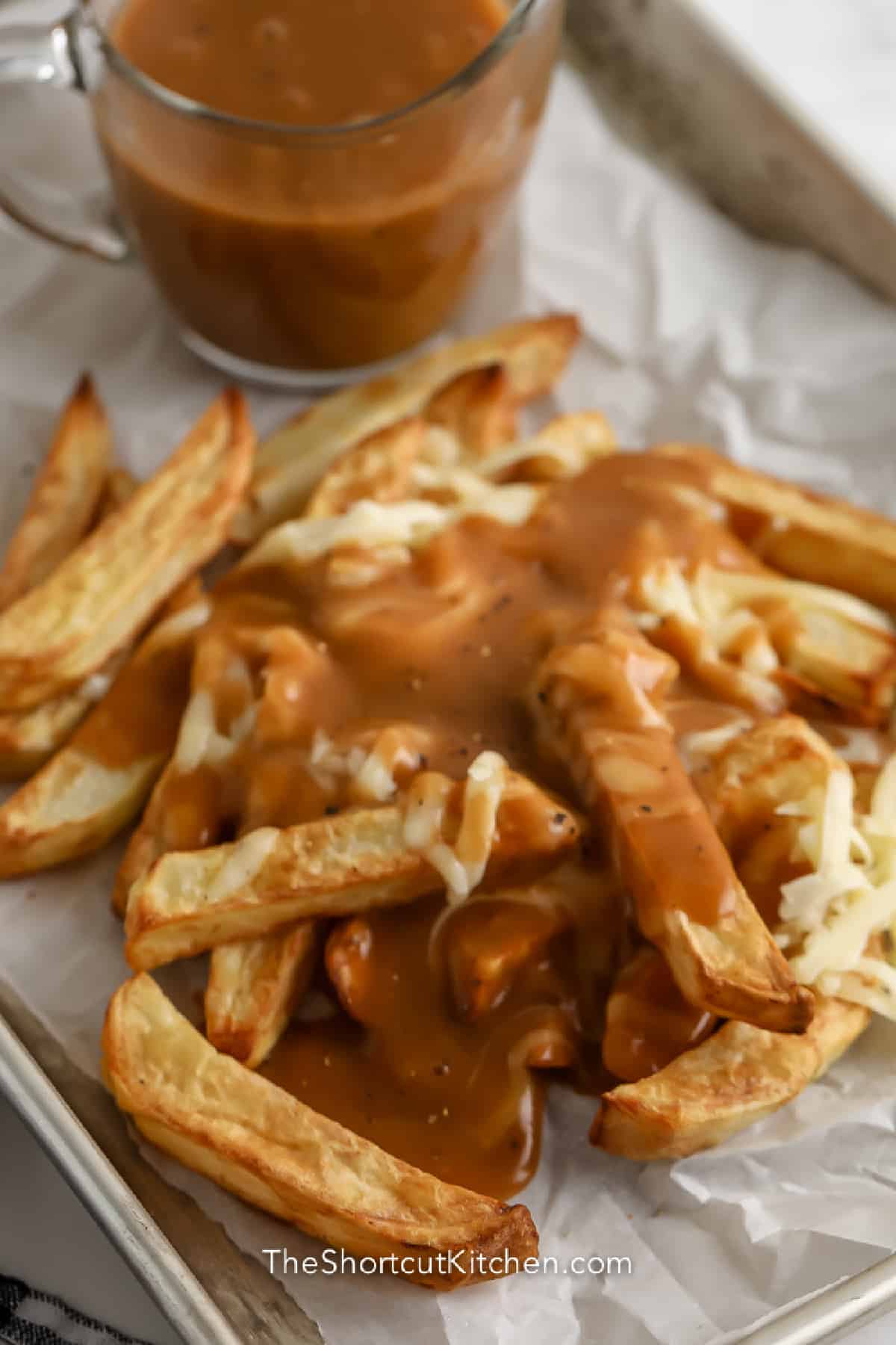 parchment lined tray of fries with cheese and gravy