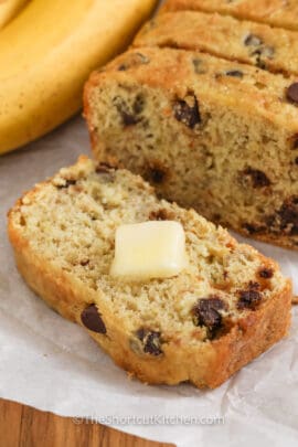 sliced Cake Mix Banana Bread with butter on top and banana in the background