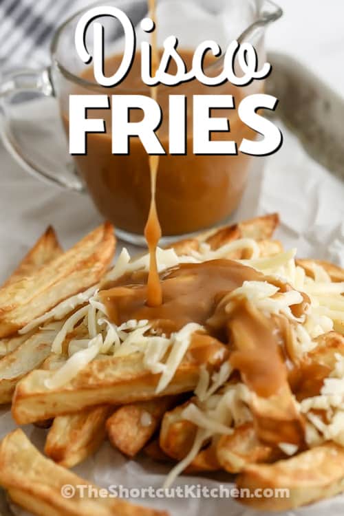 gravy poured over parchment lined tray of fries with cheese, with text