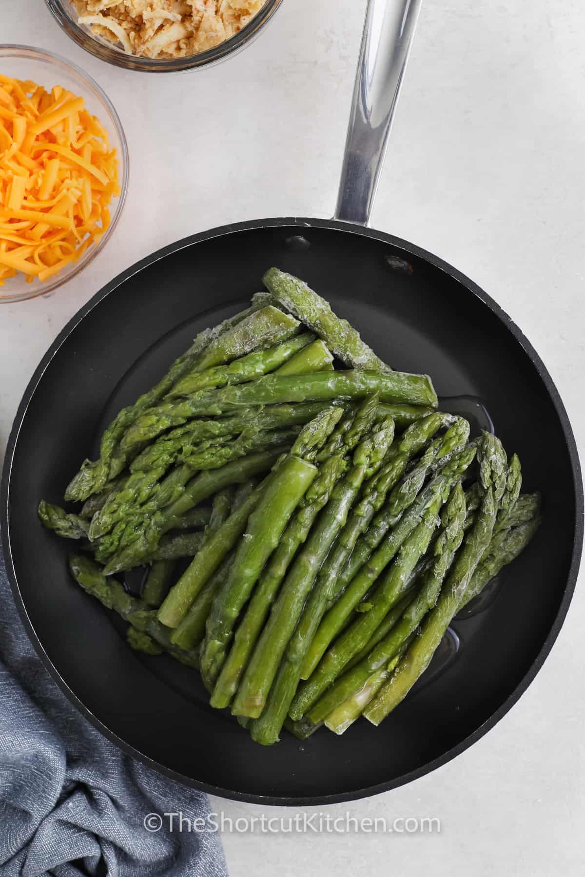 Frozen asparagus in a frying pan
