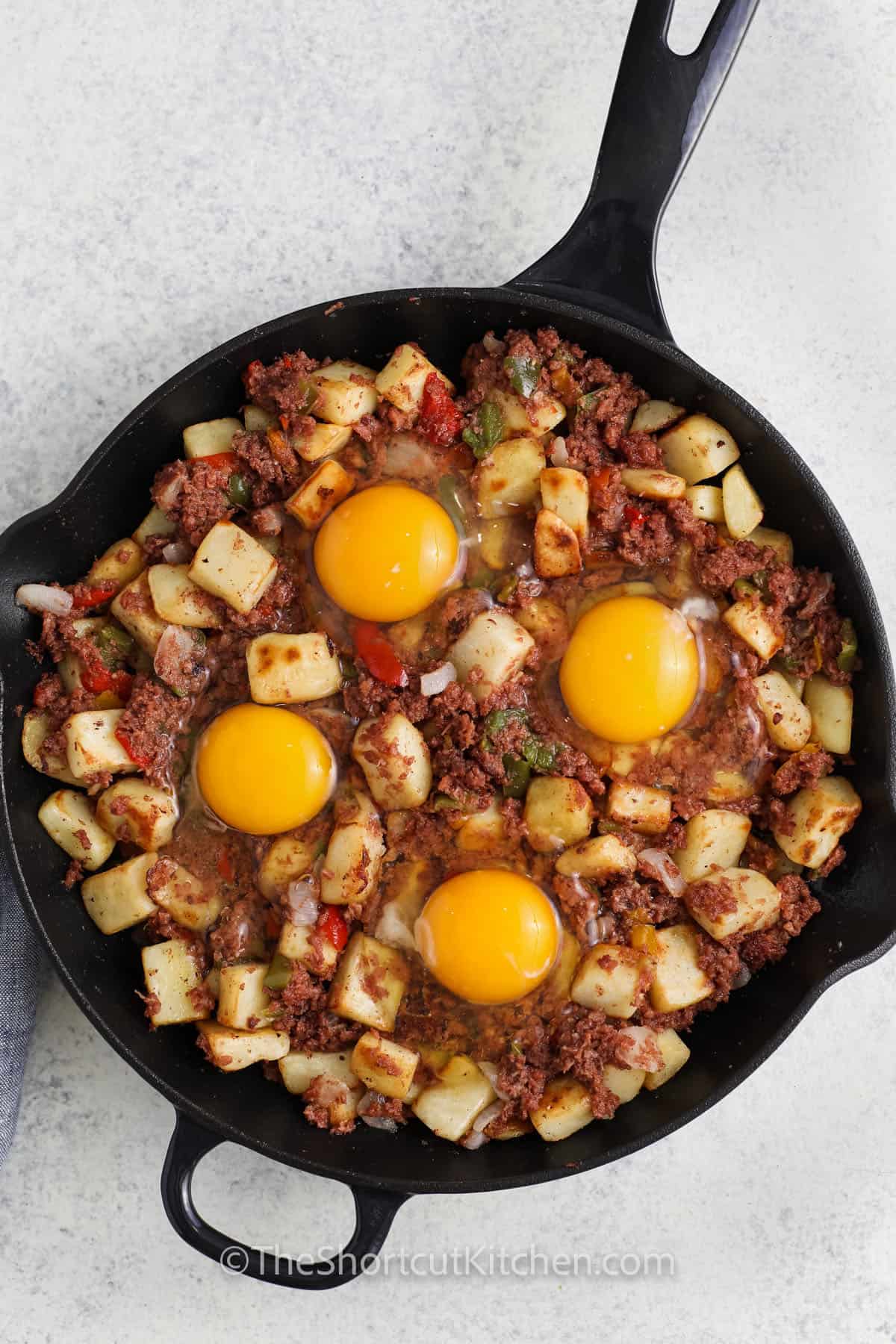 adding egg to pan to make Canned Corned Beef Hash