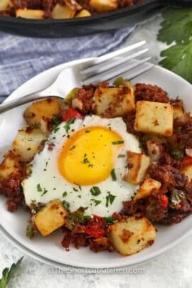 Canned Corned Beef Hash on a plate with a fork