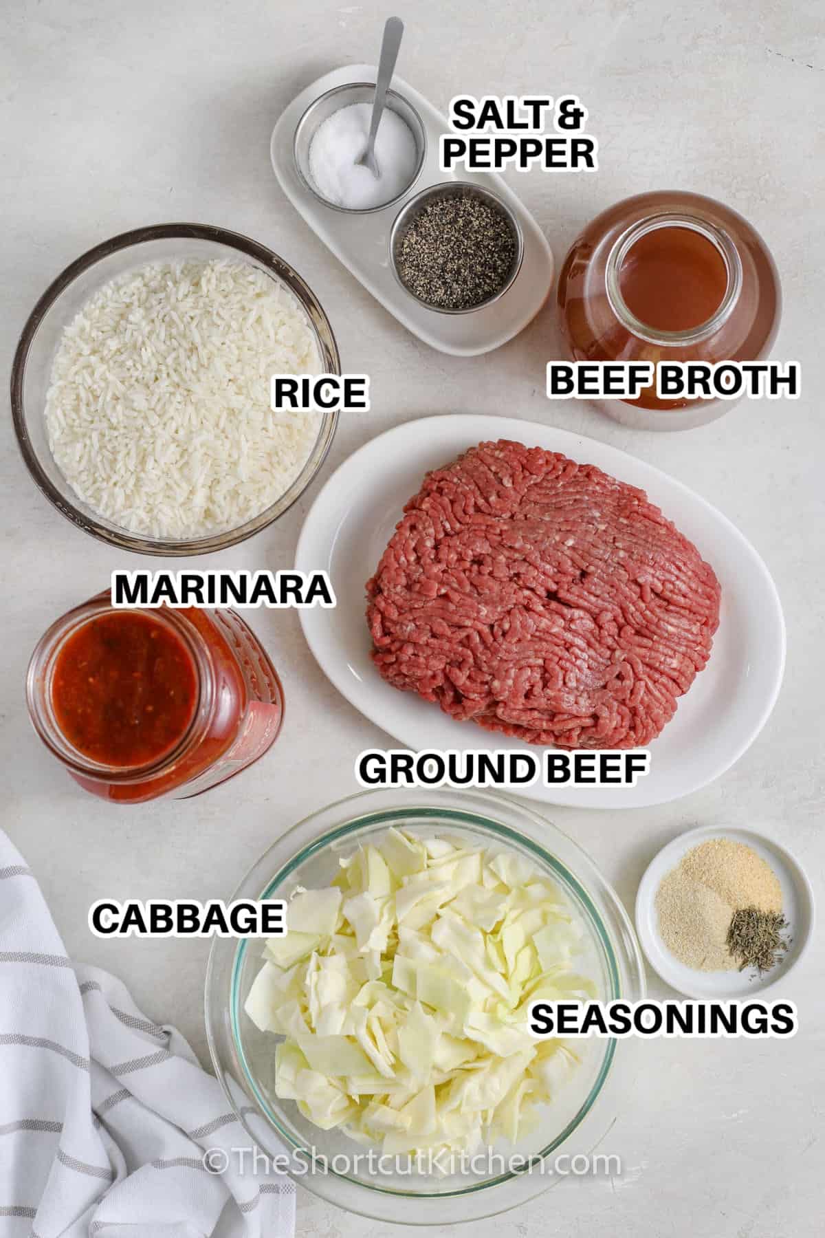 Ingredients to make Cabbage Roll Casserole labeled: salt & pepper, beef broth, rice, marinara, ground beef, cabbage, and seasonings