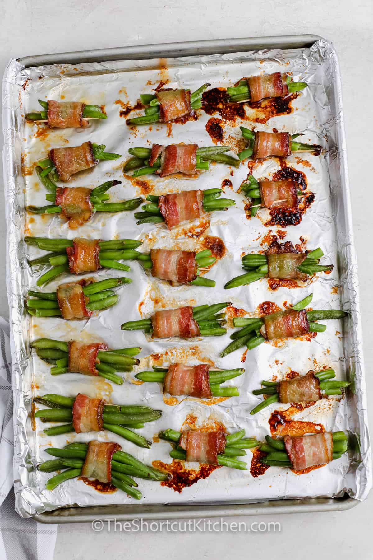 cooked Bacon Wrapped Green Beans on a sheet pan