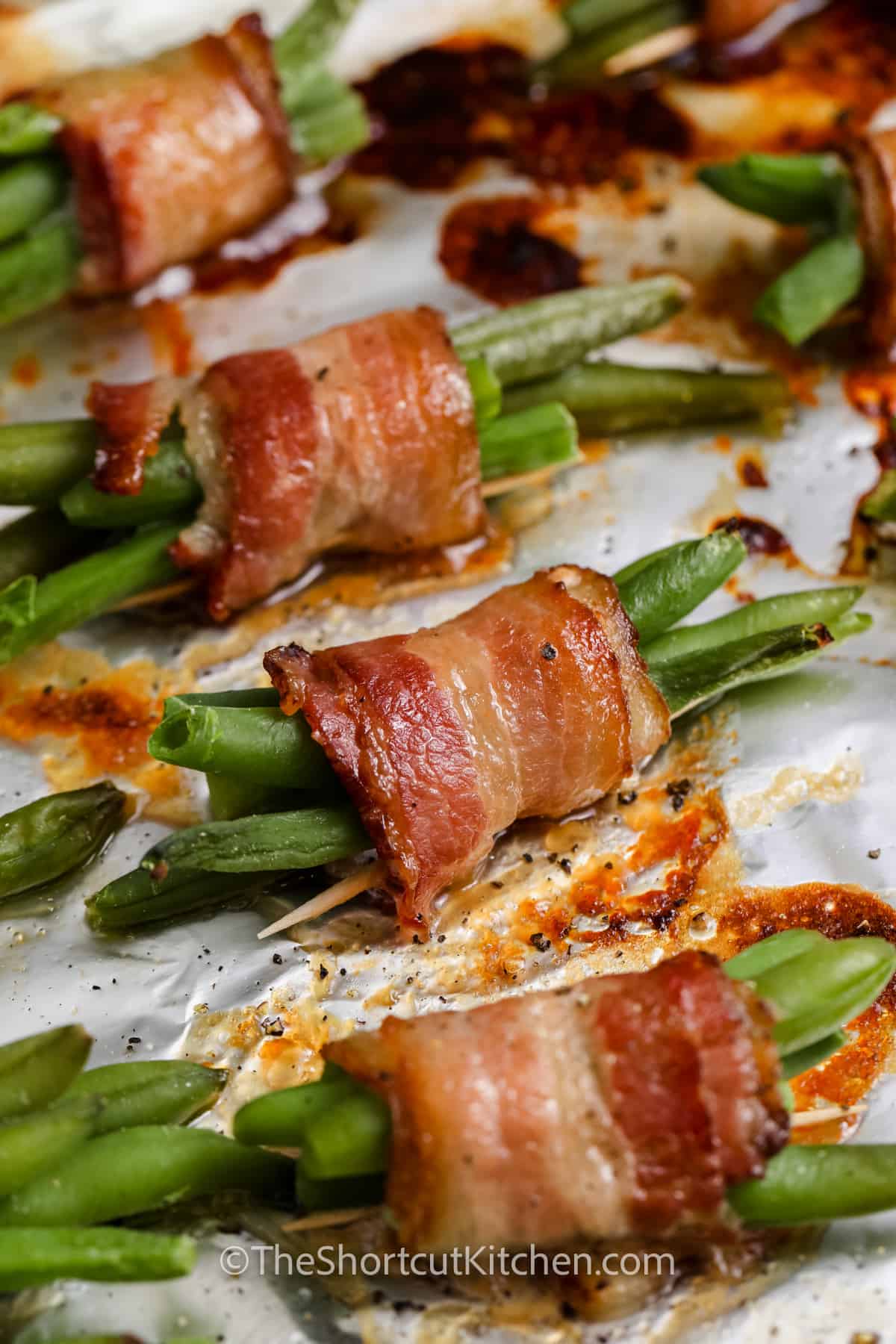 close up of Bacon Wrapped Green Beans on a sheet pan