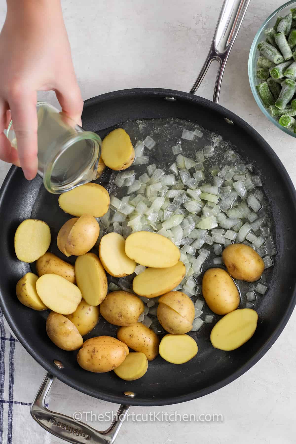 adding broth to potatoes and onion to make Green Beans and Potatoes