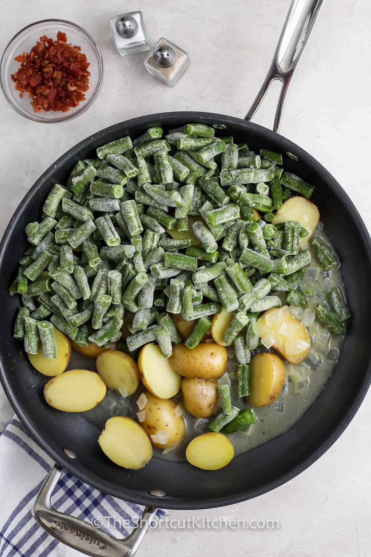 adding green teams to pan to make Green Beans and Potatoes