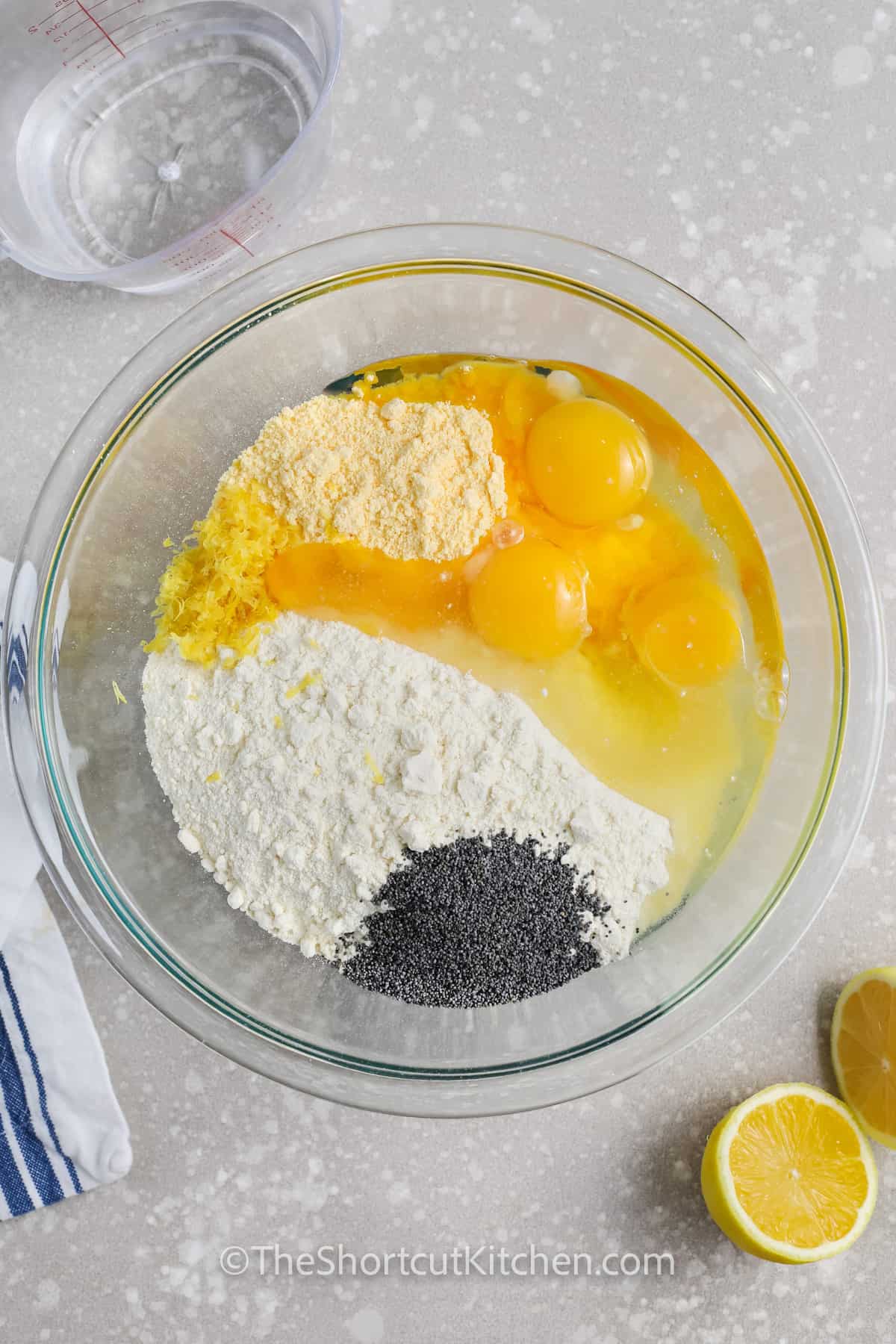 ingredients to make lemon poppyseed muffins in a bowl