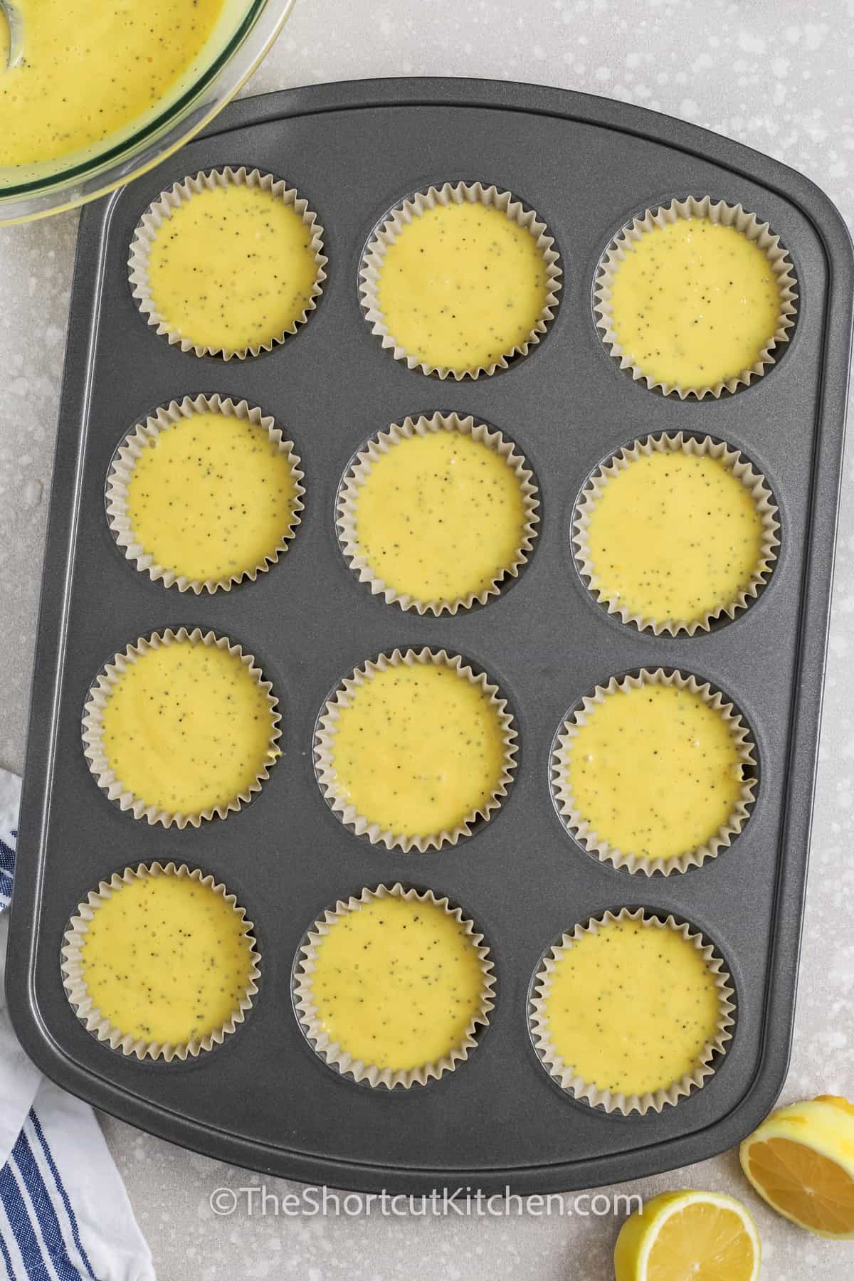 Lemon poppyseed muffin batter in a muffin tin